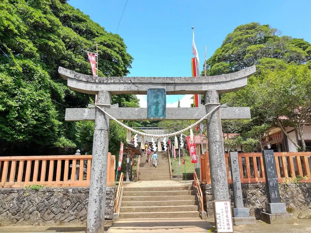 Japanese shrine entrance with stone steps and visitors